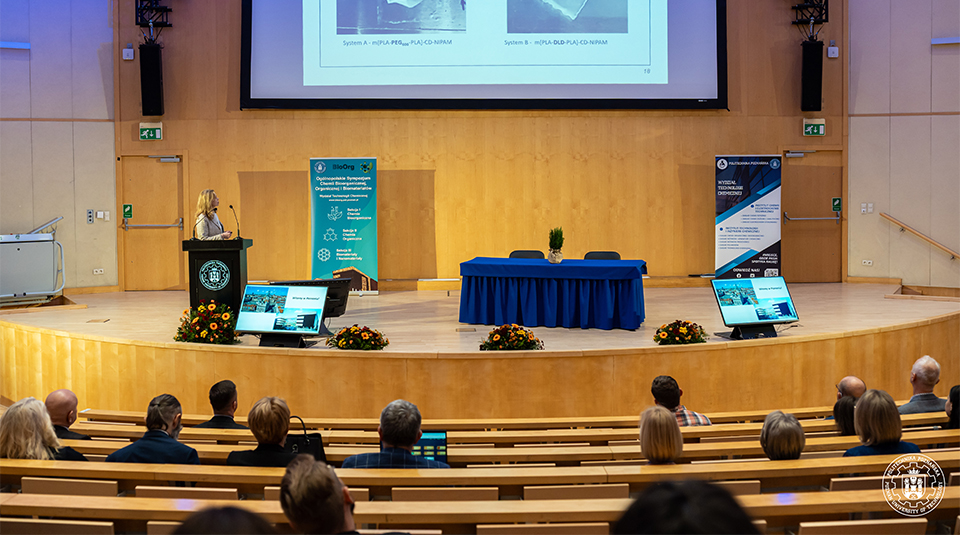 Panoramiczny widok na dużą, wypełnioną aulę wykładową Politechniki Poznańskiej podczas V Ogólnopolskiego Sympozjum Chemii Biorganicznej i Biomateriałów.